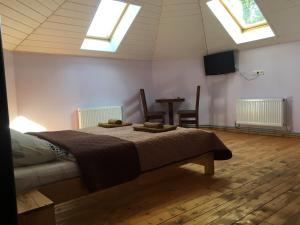 ein Schlafzimmer mit einem Bett und zwei Oberlichtern in der Unterkunft HOTEL BOBROvski in Jassinja