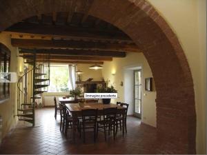 una cucina e una sala da pranzo con tavolo e sedie di Villa Case Belle a Sarteano