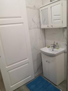 a bathroom with a sink and a white cabinet at Mario Studio in Vilnius