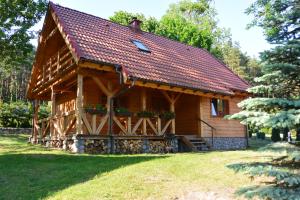 uma cabana de madeira com um telhado vermelho em Letnisko Zalesie em Rentyny