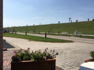 un parque con un banco y algunas flores y hierba en Kiekkast, en Norddeich