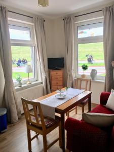 a living room with a table and two windows at Kiekkast in Norddeich