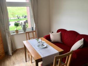 a living room with a red couch and a table at Kiekkast in Norddeich