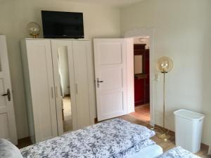 1 dormitorio con 1 cama y TV en la pared en Kiekkast, en Norddeich