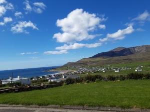 a view of a town with the ocean and mountains at Achill West Coast House in Dooagh