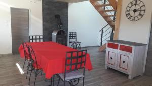 a dining room with a red table and chairs at La bottine in Ornans