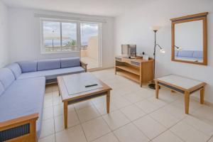 a living room with a blue couch and a table at terrazza e vista sull'oceano, Wi-Fi, piano 3, piscina sullo stesso piano in Morro del Jable