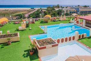 an image of a resort with a swimming pool and the beach at terrazza e vista sull'oceano, Wi-Fi, piano 3, piscina sullo stesso piano in Morro del Jable