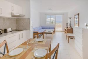 a kitchen and living room with a table and chairs at terrazza e vista sull'oceano, Wi-Fi, piano 3, piscina sullo stesso piano in Morro del Jable
