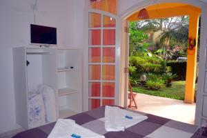 a room with a bed and a door to a patio at Pousada Capim Melado in Ubatuba
