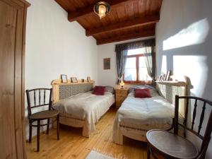 a bedroom with two beds and a table and chairs at Bakonyi Vadász Háza in Bakonykúti