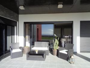 a patio with chairs and a coffee table on a patio at Mar & Serra in Feteiras