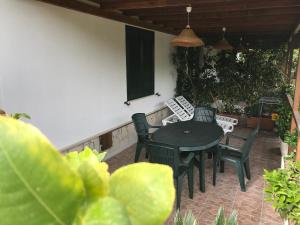patio con tavolo e sedie di Villafiorita a Gioiosa Marea