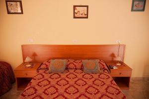 a bedroom with a red bed with two nightstands and two pillows at Parioli House in Rome