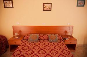 ローマにあるParioli Houseのベッドルーム1室(赤いベッド1台、ナイトスタンド2つ、枕2つ付)