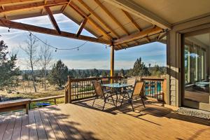 a patio with a table and chairs on a deck at Grand Cabin with Hot Tub and Views - 3 Miles to Hiking in Terrebonne