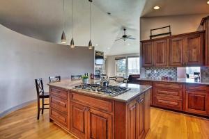 a kitchen with wooden cabinets and a stove top oven at Grand Cabin with Hot Tub and Views - 3 Miles to Hiking in Terrebonne