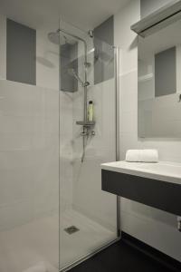 biała łazienka z prysznicem i umywalką w obiekcie Xabarin Rooms w mieście Abadín