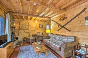 a living room with a couch and a tv in a cabin at Secluded Johnsburg Outdoor Oasis - Private Hot Tub in Johnsburg