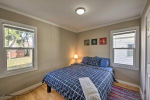 a bedroom with a blue bed and two windows at The Cozzy House 4-Minute Drive to Miller Park! in West Allis