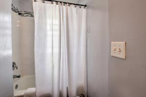 a white shower curtain in a bathroom with a tub at The Cozzy House 4-Minute Drive to Miller Park! in West Allis +16 photos