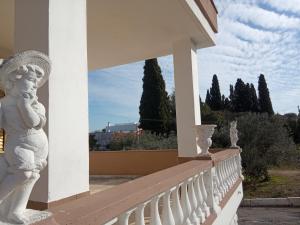 a white statue on a balcony with trees in the background at Le dimore di Flora Charme in Monopoli
