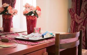 einen Tisch mit zwei Vasen und einem Blumenteller darauf in der Unterkunft Parioli House in Rom