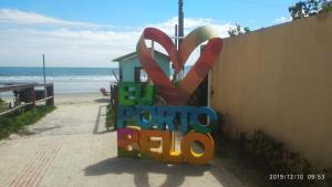 a sign for the beach with a sign for the word tomato beta at Edificio Fernanda in Porto Belo