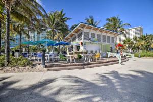 ポンパノビーチにある1 Mi to Oceanfront Fun Pompano Beach Retreat!のビーチに椅子とテーブルとパラソルのある家