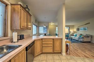 a kitchen with wooden cabinets and a living room at Cute Cottage with Deck Walk 115 Ft to Brewery and Cafe in Poulsbo