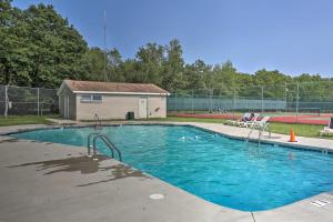 a swimming pool with blue water in front of a building at Deck, Game Room and Fire Pit Poconos Retreat in Albrightsville