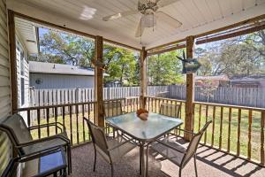 un porche cubierto con mesa de cristal y sillas en Oak Island Cottage - Walk to Beach and Intracoastal!, en Oak Island