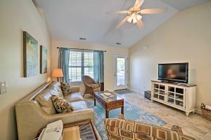 a living room with a couch and a flat screen tv at Oak Island Cottage - Walk to Beach and Intracoastal! in Oak Island
