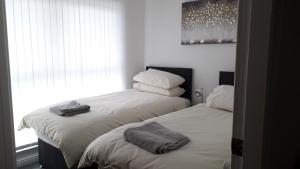 duas camas sentadas uma ao lado da outra num quarto em Lynn's Liverpool Apartment em Liverpool