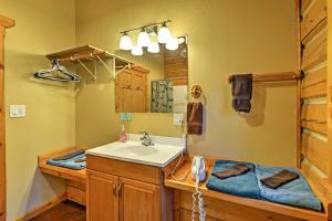 a bathroom with a sink and a mirror at Cozy Cabin on the Creek Near Hiking Trails and Town! in Seward