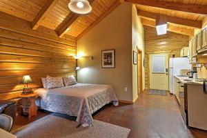 a bedroom with a bed in a room with wooden walls at Cozy Cabin on the Creek Near Hiking Trails and Town! in Seward