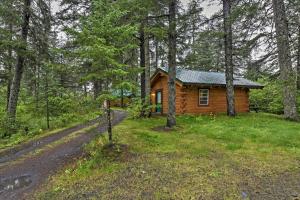 a log cabin in the woods with a dirt road at Cozy Cabin on the Creek Near Hiking Trails and Town! in Seward