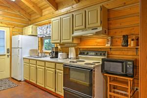 a kitchen with white appliances and wooden cabinets at Cozy Cabin on the Creek Near Hiking Trails and Town! in Seward +16 photos