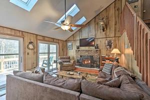sala de estar con sofá y chimenea en Bear Den Rustic Pocono Lake Home with Game Room! en Pocono Lake