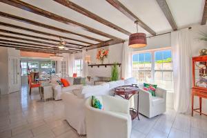 a living room with white furniture and windows at Waterfront Port Isabel Family Home with Pool and Pier! in Port Isabel