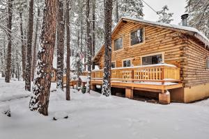 a log cabin in the woods in the snow at Furnished Deck Cabin in Coconino National Forest in Munds Park