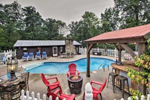 a swimming pool with red chairs and a cabin at Carters Hideaway by Fairy Stone Pool and Hot Tub in Henry