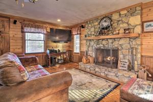 a living room with a couch and a stone fireplace at Carters Hideaway by Fairy Stone Pool and Hot Tub in Henry