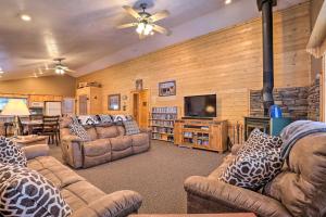 a living room with couches and a flat screen tv at Bright and Cozy Duck Creek Cabin with Grill and Fire Pit in Duck Creek Village