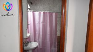 baño con cortina de ducha rosa y lavamanos en India en Chascomús