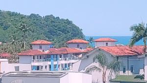 een groot wit gebouw met rode daken bij Apto Ubatuba Praia Grande - 4 quartos - piscina privativa in Ubatuba