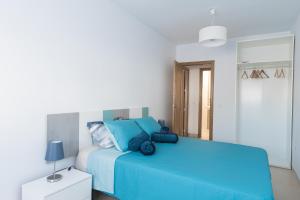 sypialnia z niebieskim łóżkiem w białym pokoju w obiekcie Casa Elena - Cabo de Gata w mieście Carboneras