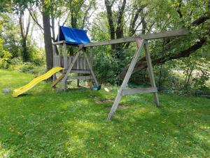 a wooden playground with a slide and a slideintend at Rainbow Ridge Farms in Onalaska