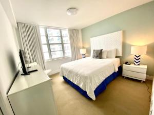 a bedroom with a bed and a flat screen tv at Seacoast by Miami Ambassadors in Miami Beach