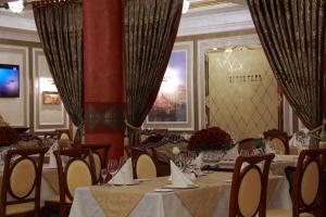 jadalnia ze stołami, krzesłami i zasłonami w obiekcie Hotel Aristokrat w mieście Połtawa